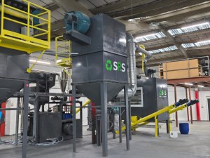 A solar panel recycling plant, with a machine in the foreground labelled "SRS".