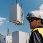 A person stands in front of a BESS unit